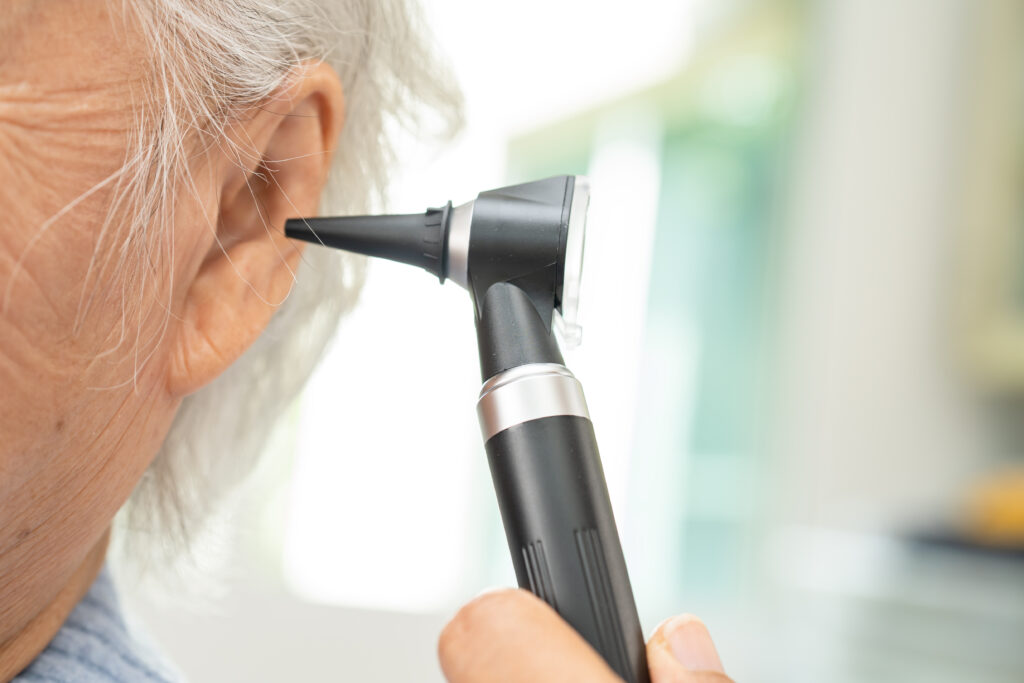 audiologist or ent doctor use otoscope checking ear of asian sen