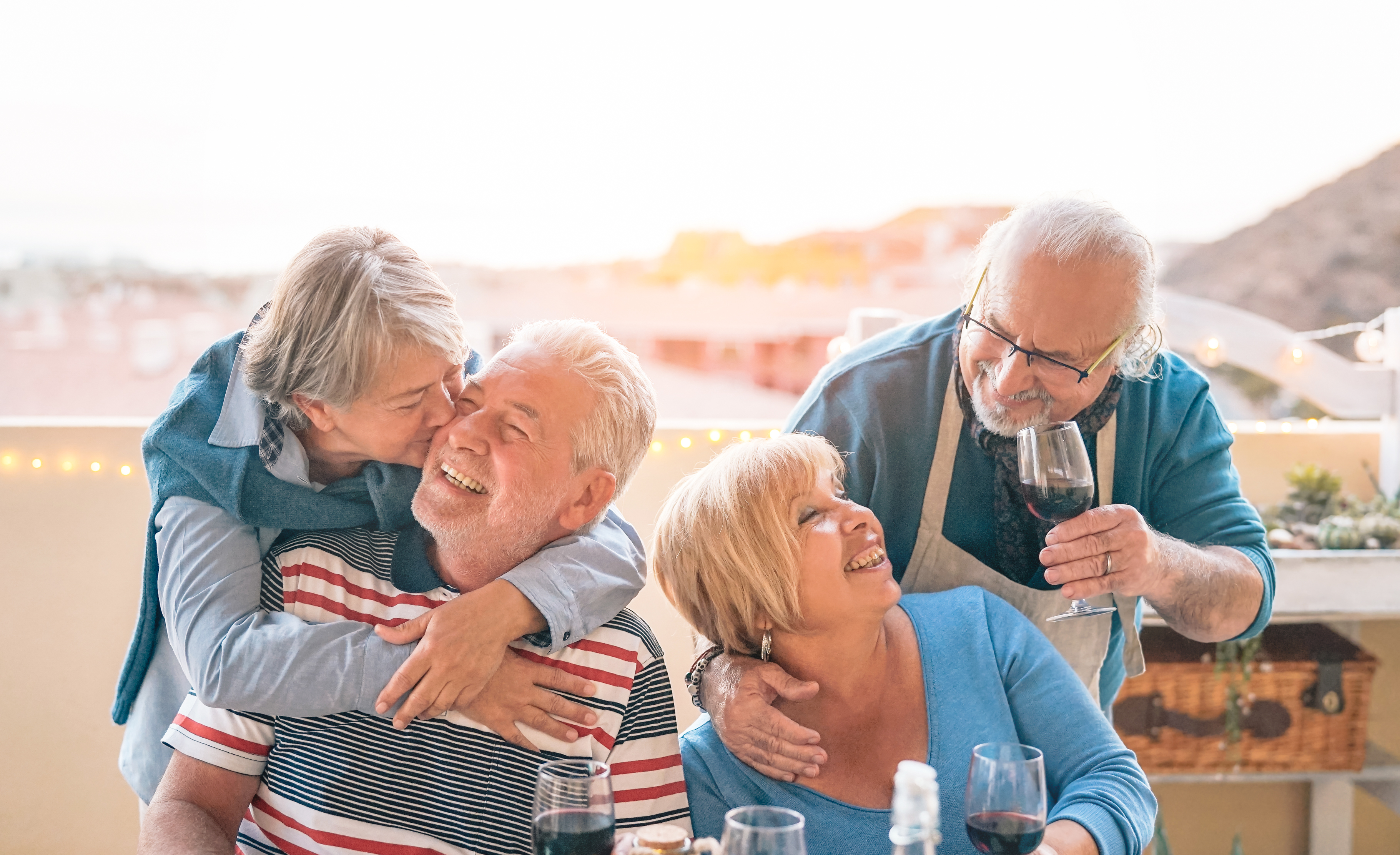 happy seniors couple having fun dining together on terrace rom
